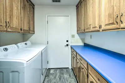 a kitchen with wooden cabinets and a washer and dryer at Charming Home Less Than 10 Mi to Sequoia Natl Park! in Three Rivers