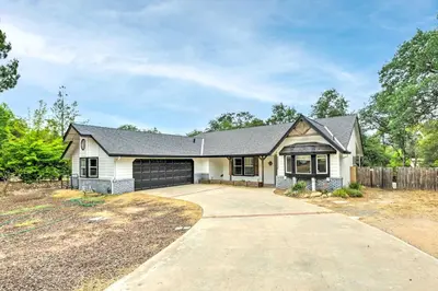 a house with a garage and a fence at Charming Home Less Than 10 Mi to Sequoia Natl Park! in Three Rivers