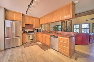 a kitchen with wooden cabinets and stainless steel appliances at Wraparound Deck and Pool Access Truckee Cabin in Truckee