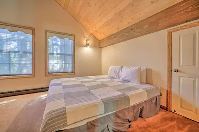 a bedroom with a bed and two windows at Wraparound Deck and Pool Access Truckee Cabin in Truckee