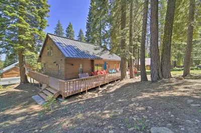 a cabin in the woods with a porch and trees at Wraparound Deck and Pool Access Truckee Cabin in Truckee