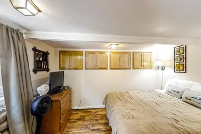 a bedroom with a bed and a tv on a dresser at Lakefront Retreat in Bass Lake