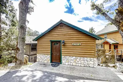a log cabin with a door in front of it at Lakefront Retreat in Bass Lake