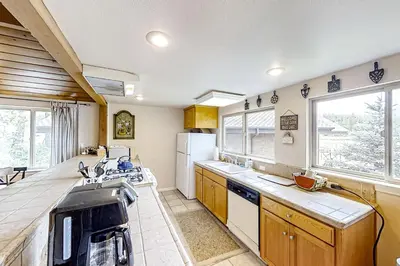 a kitchen with a sink and a refrigerator at Lakefront Retreat in Bass Lake