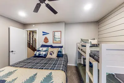 a bedroom with two bunk beds and a ceiling fan at Huntington Lake Condo #102 in Lakeshore