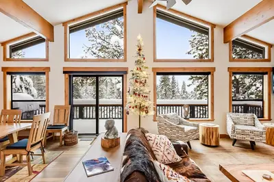 a living room with a large couch and windows at 17th Tee Lake Tahoe Retreat in Incline Village