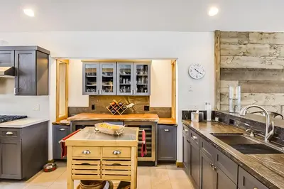 a large kitchen with gray cabinets and a sink at 17th Tee Lake Tahoe Retreat in Incline Village