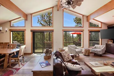 a living room with large windows and a dining room at 17th Tee Lake Tahoe Retreat in Incline Village