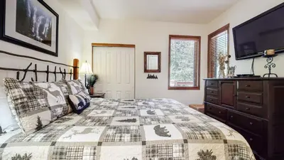 a bedroom with a bed and a tv on the wall at Eagle Run #114 condo in Mammoth Lakes