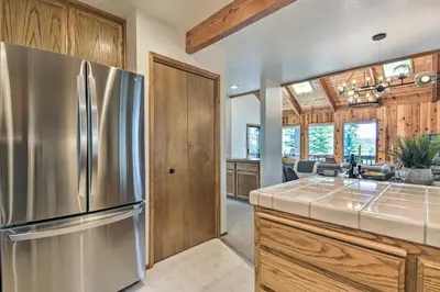 a kitchen with a stainless steel refrigerator and wooden cabinets at Hike, Fish, and Relax Family Arnold Cabin in Arnold