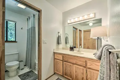 a bathroom with a sink and a toilet and a mirror at Hike, Fish, and Relax Family Arnold Cabin in Arnold