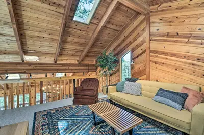 a living room with a couch and a chair in a cabin at Hike, Fish, and Relax Family Arnold Cabin in Arnold