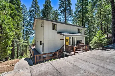 a house in the woods with a large deck at Hike, Fish, and Relax Family Arnold Cabin in Arnold