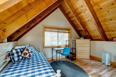 a bedroom with a bed and a desk in a attic at Toast of the Mountain Town in Truckee