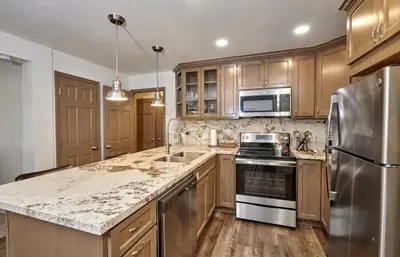a kitchen with wooden cabinets and stainless steel appliances at St Anton Condos #49 condo in Mammoth Lakes