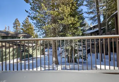 a fence in the snow in front of a house at St Anton Condos #49 condo in Mammoth Lakes