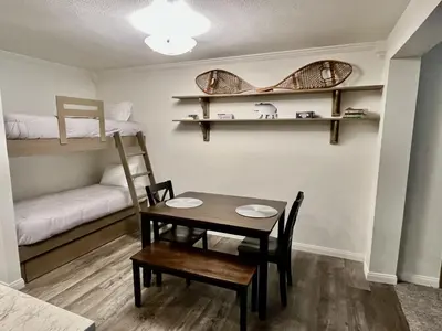 a dining room with a table and chairs and bunk beds at St Anton Condos #49 condo in Mammoth Lakes