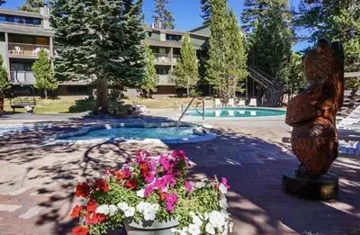 a statue of a bear and flowers in front of a pool at St Anton Condos #77 condo in Mammoth Lakes