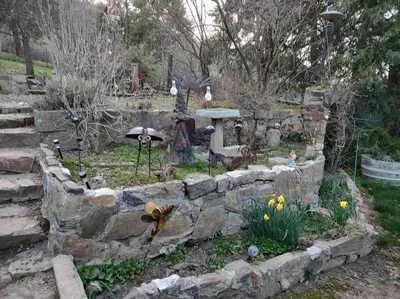 a garden with a stone wall and some flowers at O'Brien's Oasis in Miramonte