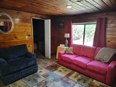 a living room with a red couch and a chair at O'Brien's Oasis in Miramonte