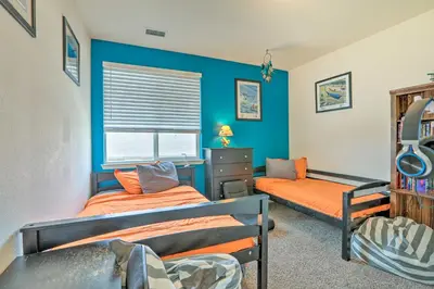 two beds in a room with blue walls at Air Racing Decor, Hot Tub Sparks Home! in Sparks