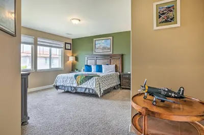 a bedroom with a bed and a gun on a table at Air Racing Decor, Hot Tub Sparks Home! in Sparks