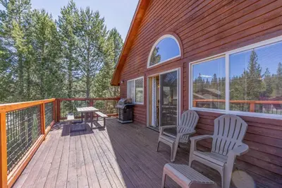 a deck with two chairs and a grill on a house at Less Than 8 Mi to Donner Lake Home with Deck and Balcony! in Truckee