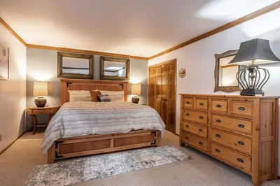 a bedroom with a bed and a dresser and a mirror at Mammoth Pines #7 Newly updated 2 Bedroom plus Loft, 3 Full Bathrooms, Sleeps 8 people in Mammoth Lakes