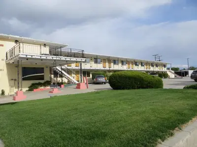 a building with a car parked in a parking lot at Holiday Lodge in Hawthorne