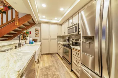 a kitchen with stainless steel appliances and wooden floors at Mountainback 100 in Mammoth Lakes