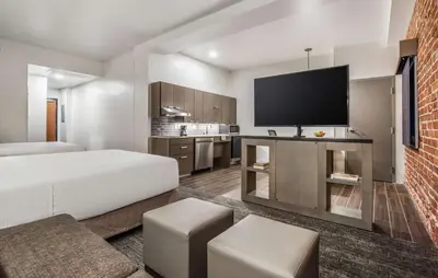 a hotel room with a bed and a flat screen tv at Hyatt House Sacramento-Midtown in Sacramento
