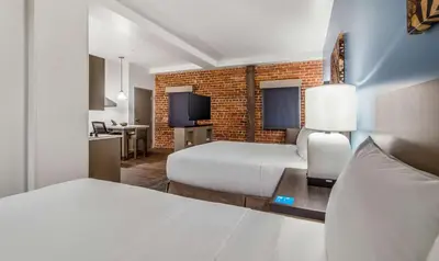 a bedroom with two beds and a brick wall at Hyatt House Sacramento-Midtown in Sacramento