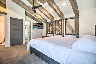 a bedroom with a large white bed and some windows at Luxe Mountain Home in Village, Steps to Gondola! in Mammoth Lakes
