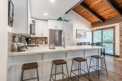 a kitchen with a large counter with stools at Horizons IV #156 New Luxurious Listing! Fully Remodeled 2 Bedroom Plus Loft 3 Full Bathroom Sleeps 8 in Mammoth Lakes