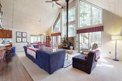 a living room with two blue couches and a kitchen at Falcon Point Pines in Truckee
