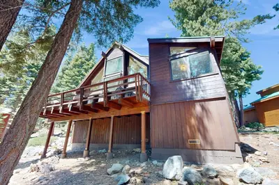 a tree house with a deck in the woods at Falcon Point Pines in Truckee