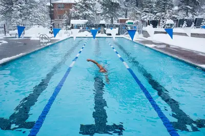 a person swimming in a swimming pool in the snow at Falcon Point Pines in Truckee