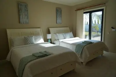 two beds in a bedroom with a window at 4BR LUXURY ENTERTAINMENT OASIS in Tracy