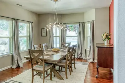 a dining room with a table and chairs and windows at Wooded Bliss in Mariposa