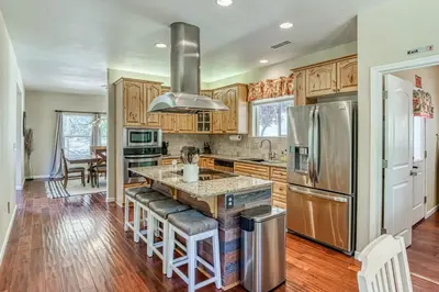 a kitchen with wooden cabinets and a stainless steel refrigerator at Wooded Bliss in Mariposa
