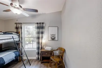 a bedroom with a bed and a desk and a window at Out in the Wild in Oakhurst