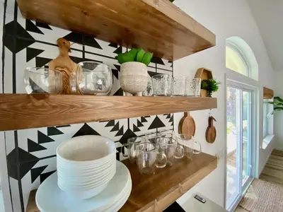 a shelf with plates and glasses on a wall at Sunset Glow Hidden Meadow BBQ HotTub by Casa Oso in Oakhurst