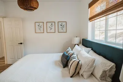 a bedroom with a bed with pillows and a window at Sunset Glow Hidden Meadow BBQ HotTub by Casa Oso in Oakhurst
