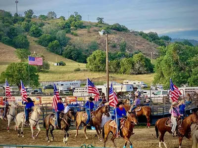 a group of people riding horses holding american flags at Sunset Glow Hidden Meadow BBQ HotTub by Casa Oso in Oakhurst
