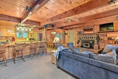 a living room with a couch and a kitchen and a bar at Comfortable Mi-Wuk Village Cabin Hike and Ski! in Mi-Wuk Village