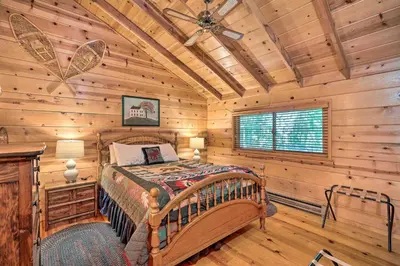 a bedroom with a bed in a log cabin at Comfortable Mi-Wuk Village Cabin Hike and Ski! in Mi-Wuk Village