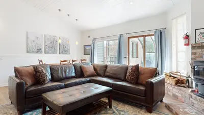 a living room with a brown leather couch and a fireplace at Forest Creek #15 condo in Mammoth Lakes