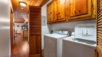 a laundry room with a washer and a kitchen at Whiskey Springs by AvantStay Classic Cabin Near Tahoe Donner Ski Area in Truckee