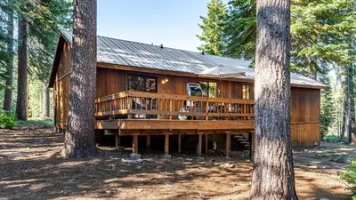a large wooden cabin in the woods with trees at Whiskey Springs by AvantStay Classic Cabin Near Tahoe Donner Ski Area in Truckee