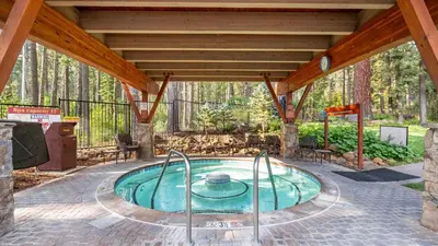 a swimming pool in a patio with a wooden roof at Arroyo by AvantStay Peaceful Mountain Townhouse w Large Private Balcony in Kingswood Estates